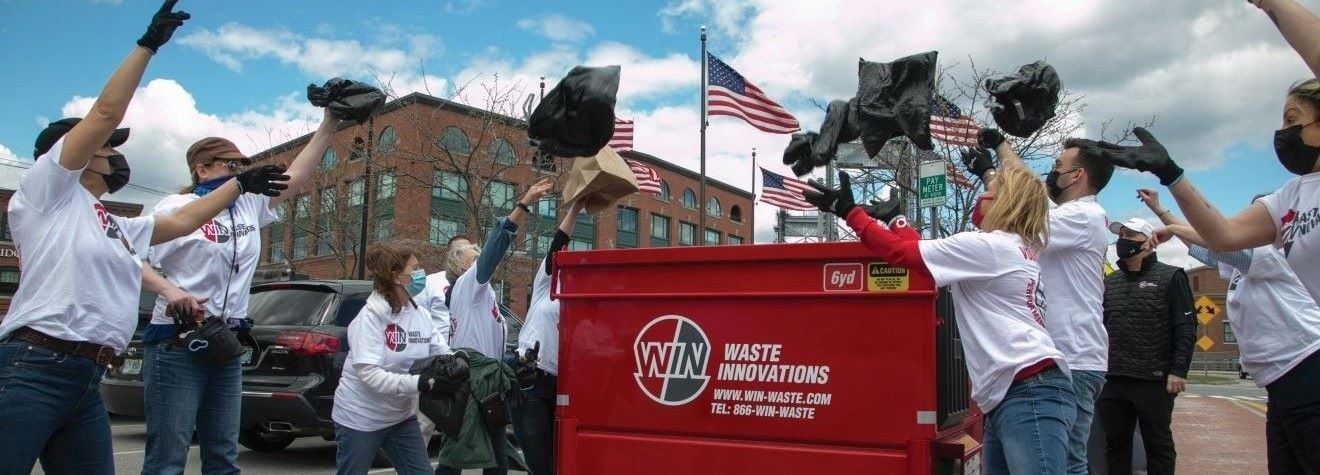 WIN employees throwing trash in dumpster
